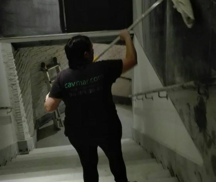 Trabajadora limpiando las escaleras de un edificio